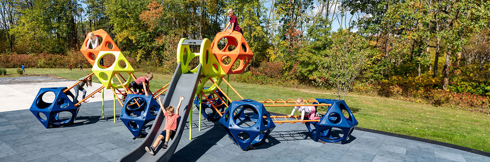 Large playground structure made with geometric play cube structures, some are plastic and some metal.